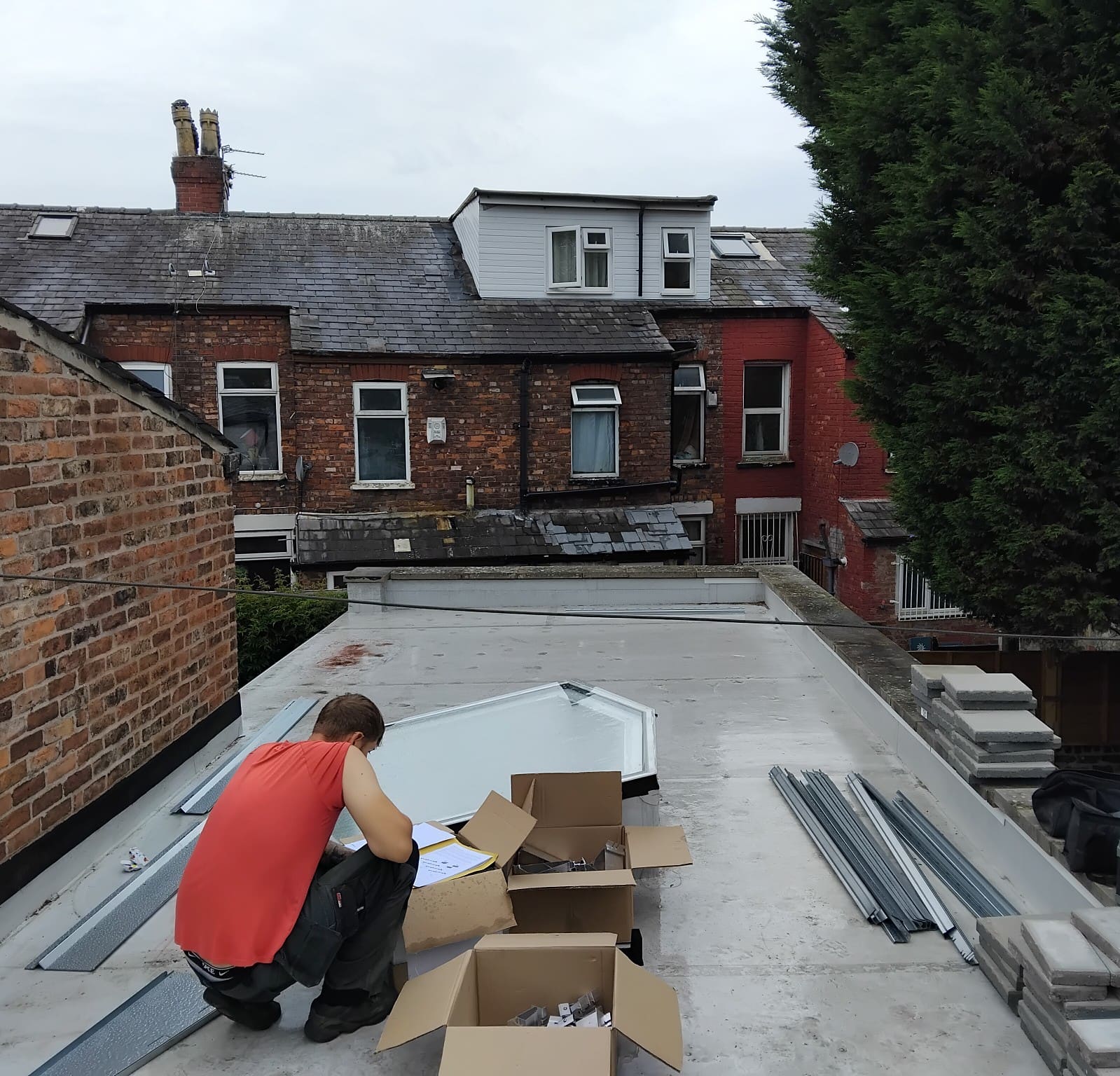 Flat roof solar panel installation split around a roof lantern, parapets and several roof sections