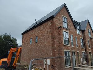 New build houses with scaffolding and solar panels being installed