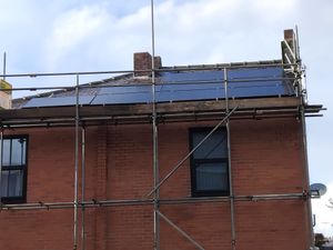 Solar panels installed on pitched roof with scaffolding in Failsworth
