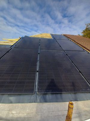 Solar panels installed on a red tile roof, in progress - view from the scaffold