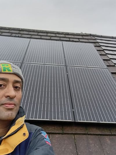 Ashley Merritt, installing solar panels on a roof
